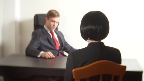 En man i kostym ställer frågor till en brunett kvinna i en intervju. 4 k. intervju. rekrytering — Stockvideo