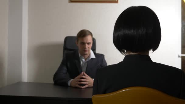 Un hombre de traje le hace preguntas a una morena en una entrevista. 4k. entrevista. contratación de personal — Vídeos de Stock
