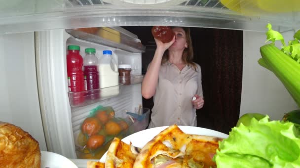 Žena otevírá lednici v noci. Noční hlad. strava. obžerství, 4k — Stock video