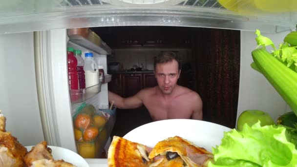 Молодий м'язистий чоловік відкриває холодильник вночі. нічний голод. дієта. глушіння, 4k — стокове відео