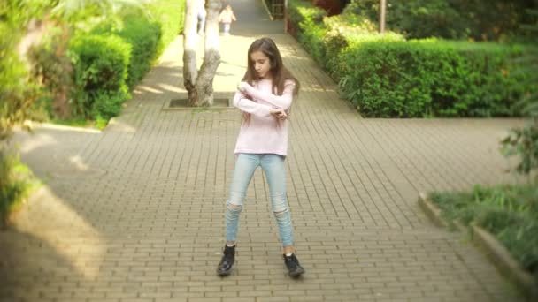 4k. stylish girl with long hair dancing modern dance in a city park. — Stock Video