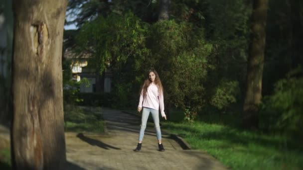 4 k. snygg tjej med långt hår dansa modern dans i en stadspark. — Stockvideo