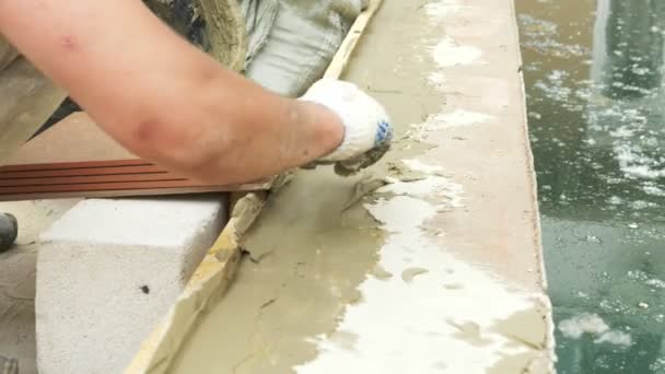 Spatula and bucket with mortar on the construction site. the builder finishes the surface with plaster. 4k. pool repair. — Stock Video