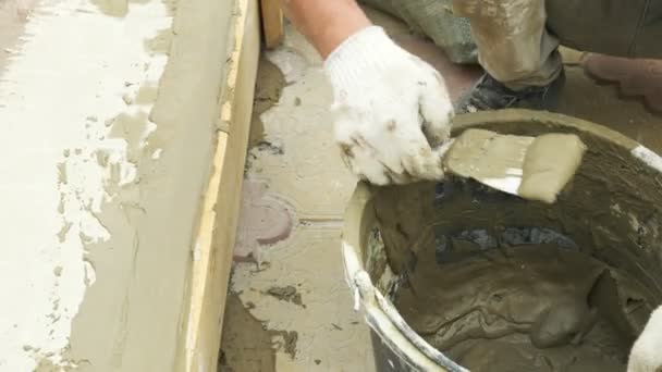 在工地上用灰泥铲和水桶。建筑工人用石膏完成表面。4k. — 图库视频影像