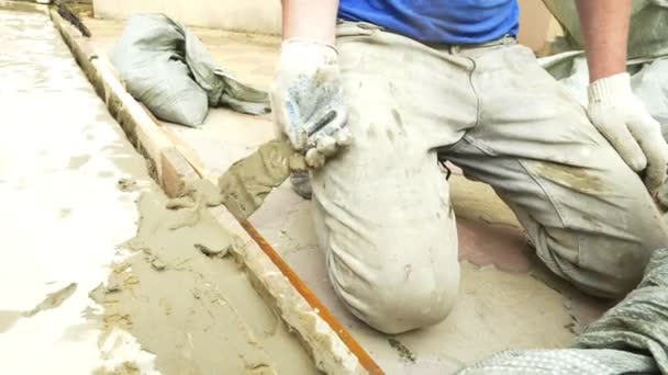 Spatel en emmer met mortel op de bouwplaats. de bouwer eindigt het oppervlak met pleister. 4k. — Stockvideo