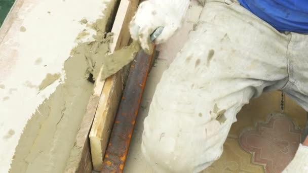 Spatel och hink med murbruk på byggarbetsplatsen. byggaren avslutar ytan med gips. 4k. — Stockvideo