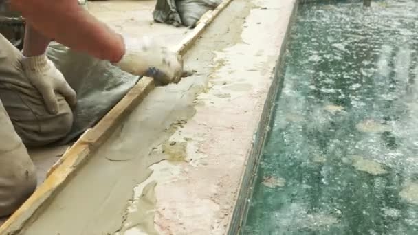 Espátula y cubo con mortero en el sitio de construcción. el constructor termina la superficie con yeso. 4k. reparación de piscina . — Vídeos de Stock