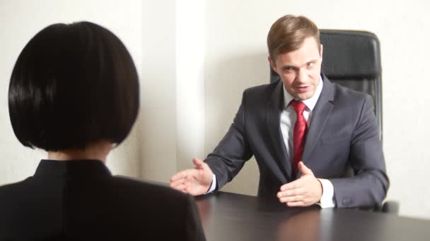 スーツの男はインタビューでブルネットの女性に質問です。4 k. インタビュー。募集 — ストック動画