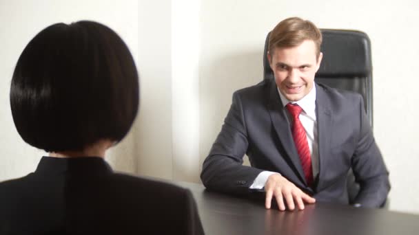 Un homme en costume pose des questions à une femme brune lors d'une interview. 4k. entretien. recrutement — Video