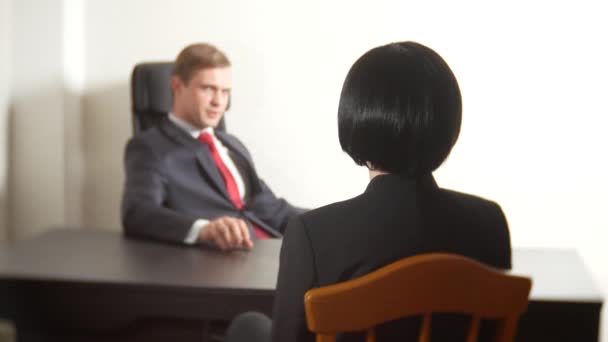 Мужчина в костюме задает вопросы брюнетке во время интервью. 4k. интервью. вербовка — стоковое видео