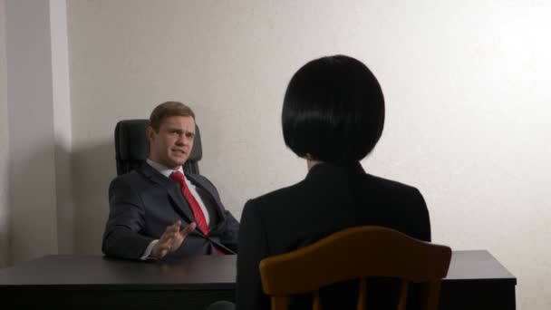 Un hombre de traje le hace preguntas a una morena en una entrevista. 4k. entrevista. contratación de personal — Vídeos de Stock