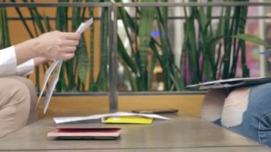 yakın çekim, 4k, Cafe işareti belgeleri kadın elinde. bir kafede iş toplantısı.