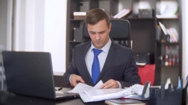 bir adam office belgeleri ve bir dizüstü bilgisayar ile çalışma tamamlanır. 4 k. sonuçta