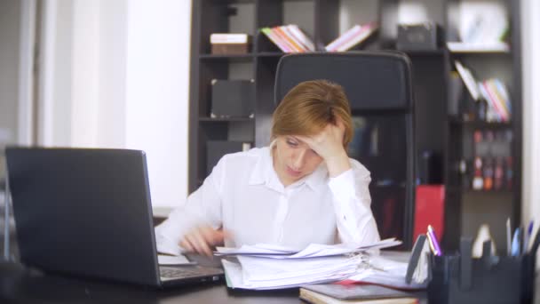 Деловая женщина, которая сканирует документы, хмурится, используя ноутбук, не выполняет срочное задание в офисе, нет достаточно времени, 4k — стоковое видео