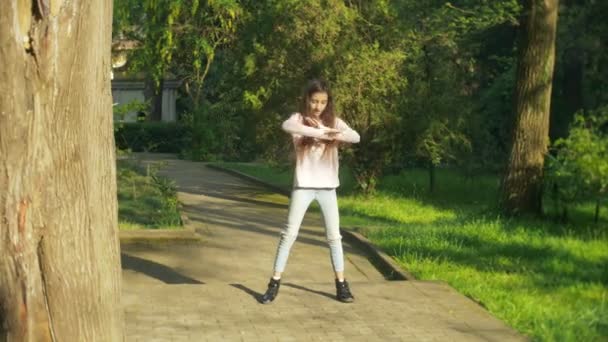 4 k. elegantní dívka s dlouhými vlasy tančí tanec v městském parku. — Stock video