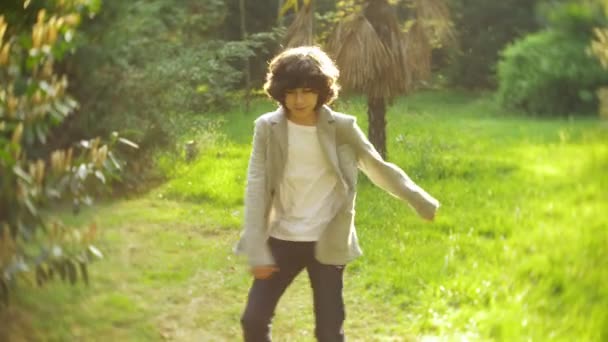 4k. beau garçon élégant adolescent danse dans un parc de la ville . — Video