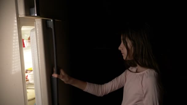 Дівчина-підліток відкриває холодильник вночі. нічний голод. дієта. глушіння, 4k — стокове відео