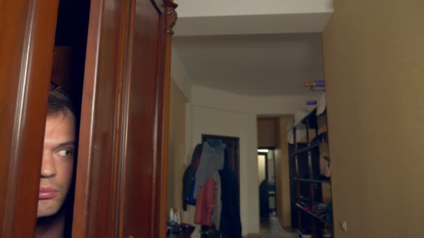 Der nackte Mann versteckt sich im Kleiderschrank. Er geht aus dem Schrank und läuft durch die Haustür aus dem Haus der Herrin. 4k, — Stockvideo