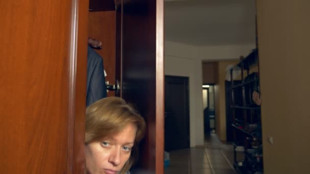 Naga kobieta ukrywa się w szafie. ona wychodzi z ukrycia i ucieka z domu miłośników frontowymi drzwiami. 4k, — Wideo stockowe
