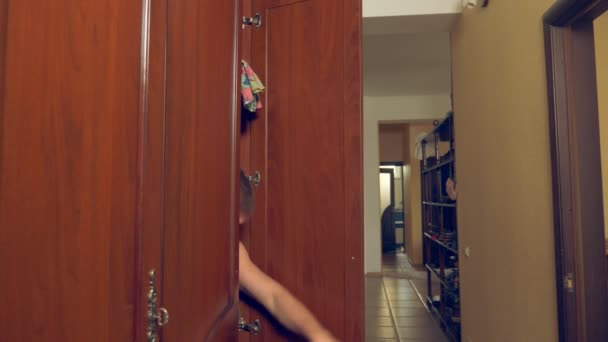 Nagi mężczyzna ukrywa się w szafie. wychodzi z ukrycia i ucieka z domu mistresss przez drzwi. 4k, — Wideo stockowe