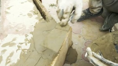 spatula ve kova ile harç inşaat alanı üzerinde. builder ile sıva yüzeyi tamamlanır. 4k.