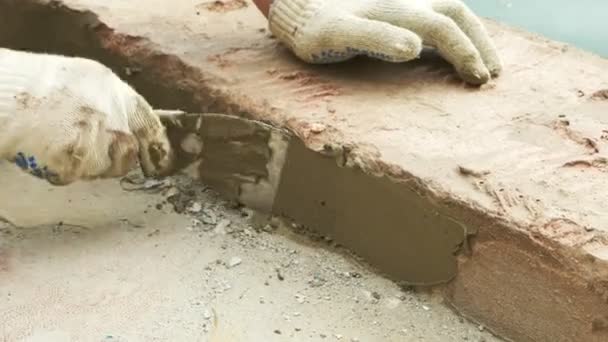 Spatula and bucket with mortar on the construction site. the builder finishes the surface with plaster. 4k. pool repair. — Stock Video