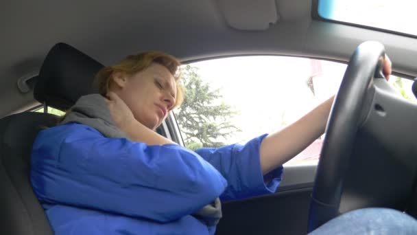 A female driver in the car is experiencing pain in the neck. 4k — Stock Video