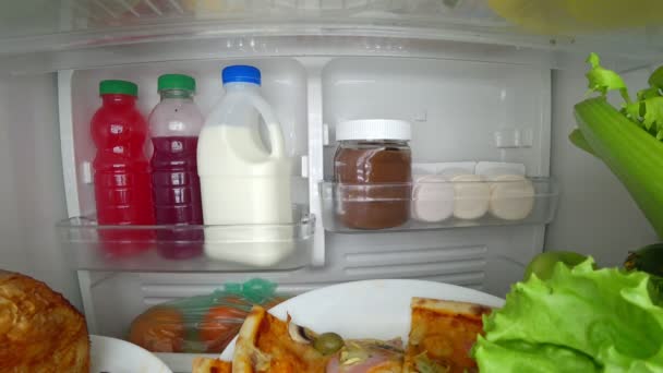 Niño comiendo frente al refrigerador en medio de la noche. 4k — Vídeo de stock