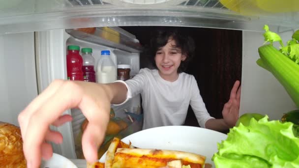 Niño comiendo frente al refrigerador en medio de la noche. 4k — Vídeo de stock