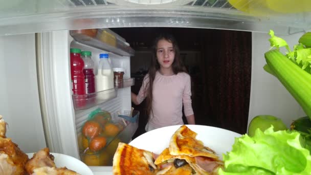 Chica adolescente abre el refrigerador por la noche. hambre nocturna. dieta. gula, 4k — Vídeo de stock