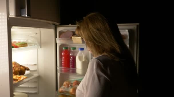 La mujer abre el refrigerador por la noche. hambre nocturna. dieta. gula, 4k — Vídeo de stock