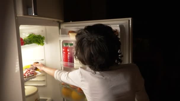 孩子在午夜的冰箱前吃。4k — 图库视频影像