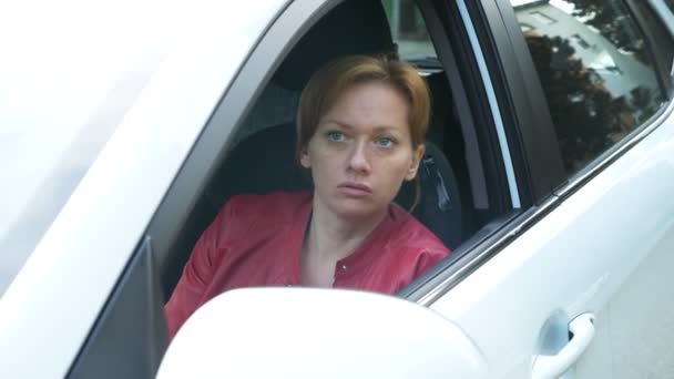 Грубість стресового і розлюченого водія автомобіля жестикуляції. жінка кричить з вікна своєї машини. 4k — стокове відео