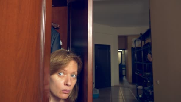 A mulher nua está escondida no guarda-roupa. Ela sai do armário e foge da casa dos amantes pela porta da frente. 4k , — Vídeo de Stock