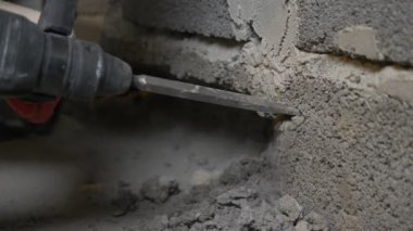 bir inşaat alanında, bir işçi bir perforator duvara vurma. 4k