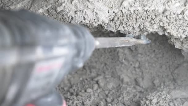 Az építkezés, a munkavállaló verni a falat egy vezeték nélküli kalapács. 4k — Stock videók