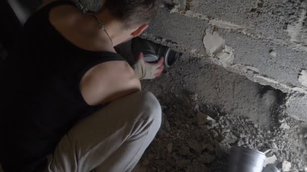 Eine Baustelle, ein Arbeiter hämmert mit einem Perforator gegen die Wand. 4k — Stockvideo