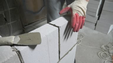 bir inşaat alanında bir Oluşturucu gaz blok duvarına koyar. 4k.