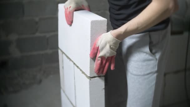 Um canteiro de obras, um construtor coloca uma parede de blocos de gás. 4k . — Vídeo de Stock