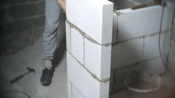Una obra de construcción, un constructor pone una pared de bloques de gas. 4k . — Vídeos de Stock