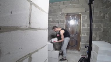 bir inşaat alanında bir Oluşturucu gaz blok duvarına koyar. 4k.