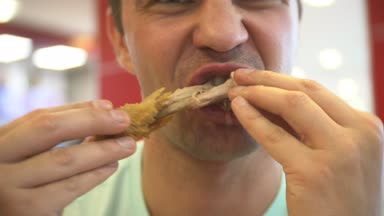 yakın çekim, adam yiyor, fast food, tavuk nuggets, kanatları ve patates kızartması. 4k