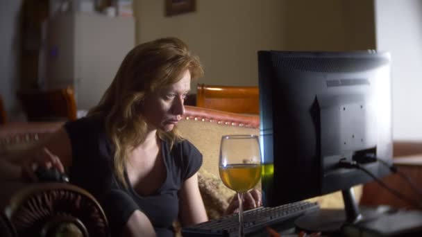 De vrouw met de computer, het drinken van bier thuis in het donker. 4k — Stockvideo