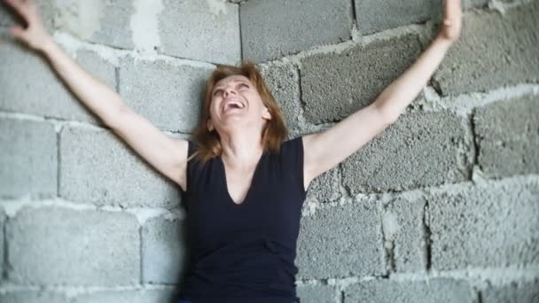 Mulher infeliz desesperada ao pé da parede. 4k, o conceito de estresse e sem esperança — Vídeo de Stock