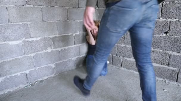 Geweld, misdaad, ontvoering, een man slaat een vrouw tegen een muur 4k, — Stockvideo