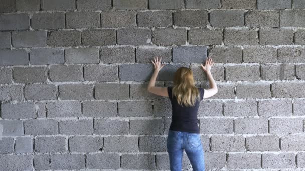 Mujer infeliz desesperada junto a la pared. 4k, el concepto de estrés y desesperación — Vídeo de stock