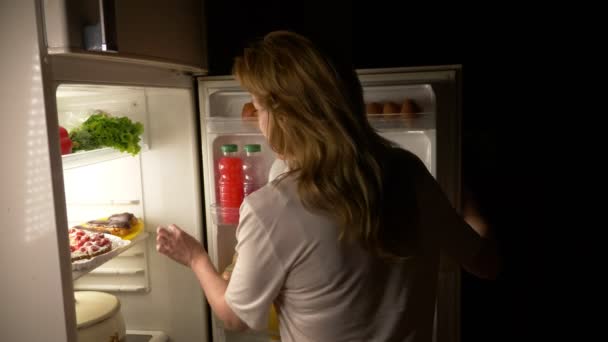 Жінка відкриває холодильник вночі. нічний голод. дієта. глушіння, 4k — стокове відео