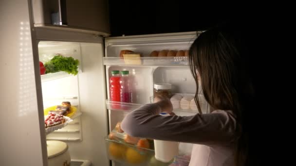 Chica adolescente abre el refrigerador por la noche. hambre nocturna. dieta. gula, 4k — Vídeos de Stock