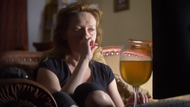 Frau mit Computer, zu Hause im Dunkeln Bier trinkend. 4k — Stockvideo