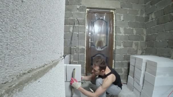 Ένα εργοτάξιο, έναν οικοδόμο βάζει έναν τοίχο μπλοκ του φυσικού αερίου. 4k. — Αρχείο Βίντεο